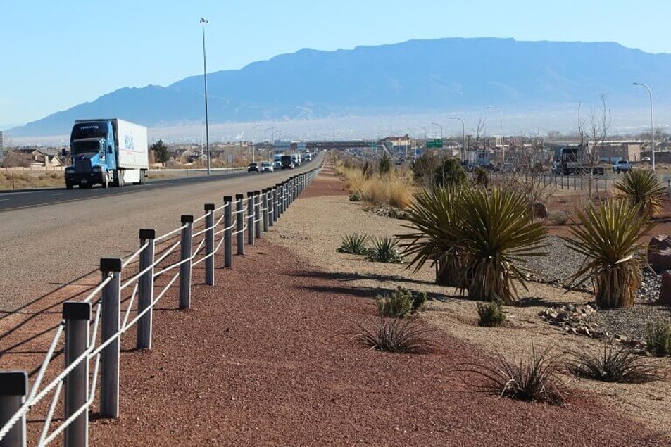 Photograph of Brifen EN1317 vehicle restraint system in the desert with a truck driving past